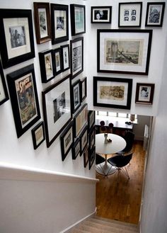 a staircase with pictures on the wall and stairs leading up to an upstairs dining area