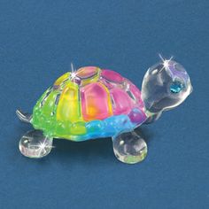 a glass turtle figurine with multicolored shell and blue eyes on a blue background