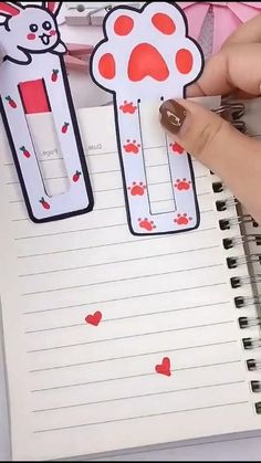 a person holding a pen and writing on a notepad with stickers attached to it