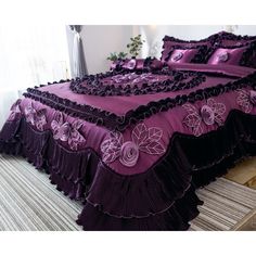 a bed with purple and black bedspreads on it