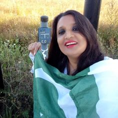 a woman holding up a green and white scarf