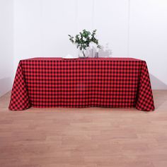 a red and black checkered table cloth with a plant in the center on top