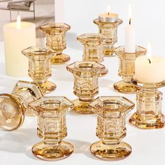 a group of glass candlesticks sitting on top of a table next to each other