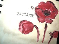 a drawing of two red flowers with japanese writing