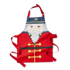 a red apron with an image of a nutcracker wearing a blue hat and coat