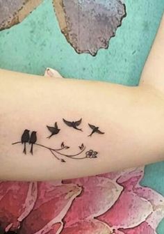 a woman's arm with birds and flowers on it