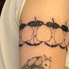 a tattoo with an image of mice and apples on the back of someone's arm