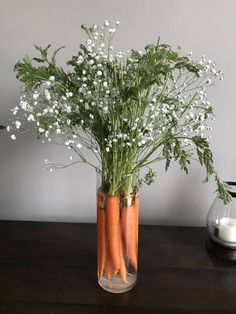 two carrots and baby's breath in a glass vase