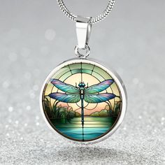 Admire the tranquil beauty of this pendant featuring an exquisitely detailed dragonfly set against a serene backdrop. Perfect for those who find peace and inspiration in nature's delicate wonders, this piece adds a touch of elegance to any ensemble. Celebrate the harmony and grace of the dragonfly with this unique and artistic accessory. Forged from premium surgical steel and available with a lavish 18k gold finish, this innovative jewelry boasts our exclusive design, handcrafted with care right Spiritual Dragonfly Jewelry Gift, Bohemian Silver Dragonfly Necklace, Sterling Silver Butterfly Necklace, Elegant Symbol, Circle Pendant Necklace, Luxury Necklace, Working Mother, Circle Pendant, Love Symbols