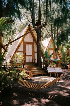 a small cabin in the woods with stairs leading up to it's roof and windows