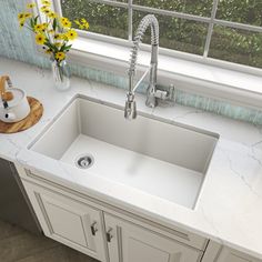 a white kitchen sink sitting under a window next to a counter top with yellow flowers