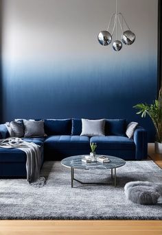 Design a serene and luxurious living room in a sophisticated gradient of blue and gray tones. The room should feature a contemporary blue sectional sofa with soft gray cushions and a matching throw blanket. A large, elegant rug with a subtle gradient design that transitions from light blue to charcoal gray should anchor the space. The coffee table could be crafted from marble with silver accents, and the walls should Blue Sectional, Elegant Rug, Gray Tones, Gradient Design