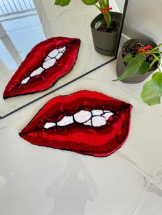 two pieces of art made to look like red lips with white teeth on the floor