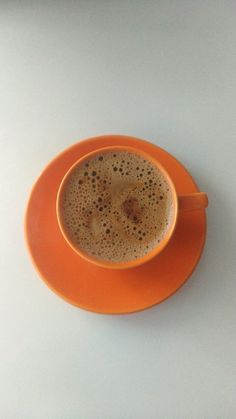 a cup of coffee on an orange saucer