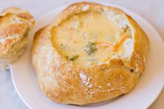 a white plate topped with two pieces of bread covered in broccoli and cheese