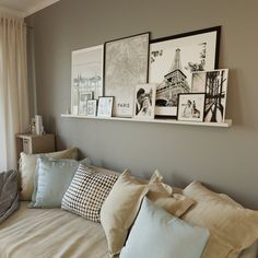 a living room filled with lots of pillows and pictures on the wall above it's couch