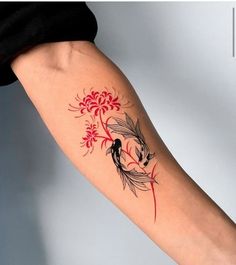 a woman's arm with a red and black tattoo design on the left forearm