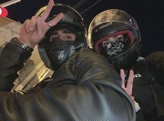 two people wearing helmets making the peace sign