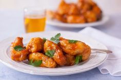 a white plate topped with fried shrimp next to a glass of beer