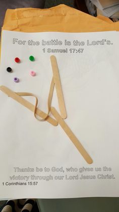 a piece of paper that has been made to look like clothes pegs and beads