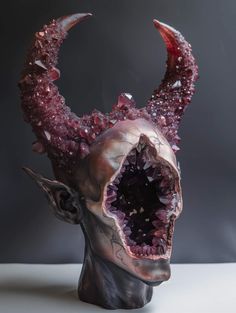 a sculpture of a demon's head with its mouth open and blood dripping from it