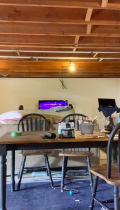 two chairs and a table in a room with wood beams on the ceiling above them