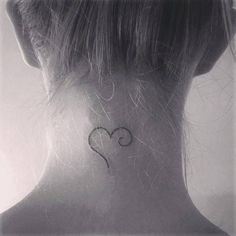 a woman with a small heart tattoo on her neck and behind her ear is the words le coeur inccheve