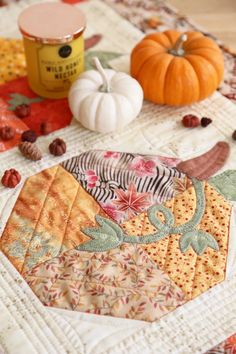 a quilted table top with some pumpkins on it