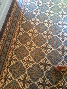 a person standing on the floor in front of a doorway with an ornate tile pattern