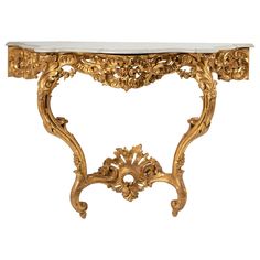 an ornate console table with marble top and gold leaf design on the base, against a white background