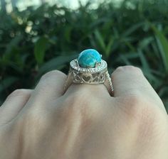 "An OOAK cabochon oval-shaped natural 6.07ct Turquoise Ring adorned with a halo of petite white topaz complimented with heart cut outs around the basket, handcrafted in sterling silver is a striking engagement/promise/statement ring. Wrapped in a box ready for gift-giving. This ring is a FINAL SALE. (r.egt.85) View our vast collection of Turquoise Rings: We can also make your custom dream ring https://www.etsy.com/shop/Belesas?ref=seller-platform-mcnav&search_query=turquoise+ring Ring Info - Oval Turquoise Jewelry With Halo Setting, Luxury Oval Turquoise Ring For Gift, Luxury Oval Turquoise Ring Gift, Turquoise Oval Jewelry With Halo Setting, Luxury Turquoise Oval Cabochon Ring, Oval Cabochon Turquoise Ring Fine Jewelry Gift, Fine Jewelry Turquoise Oval Cabochon Ring For Gift, Luxury Round Turquoise Ring For Gift, Luxury Turquoise Ring As Gift