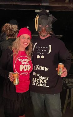 a man and woman dressed up as pirates holding beer cans in front of their faces