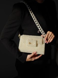 Handcrafted Beaded Pearl Bag - Elegant and Timeless Introducing our exquisite beaded pearl bag, a true embodiment of sophistication and style. Each bag is meticulously handcrafted with attention to detail, making it a unique accessory that will elevate any outfit. The timeless design of this bag makes it a versatile addition to your wardrobe. Whether you're attending a wedding, a cocktail party, or a casual brunch, this bag effortlessly complements any occasion. Compact yet spacious enough to ho Cream Rectangular Shoulder Bag With Pearl Handle, Cream Evening Bag With Pearl Handle, Elegant White Handheld Box Bag, Cream Square Shoulder Bag For Evening, Elegant White Box Bag For Gift, Cream Rectangular Evening Bag, Luxury Pouch Shoulder Bag With Pearl Handle, Pearl White Bag With Pearl Handle, Pearl White Bag With Pearl Handle Rectangular