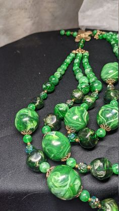 FREE SHIPPING- Vintage Multi Strand Necklace with Gold Tone Accents and Marbled Faux Jade Green Beads. See Item Description for Important info! Great Condition& Vibrant Greens~! There is a Maker's Mark signature under the Hook on the Butterfly, but it is hard to make out. FREE SHIPPING FOR ALL ORDERS GOING TO THE CONTINENTAL U.S.A (LOWER 48 STATES) ALL PURCHASES DESTINED FOR ALASKA OR HAWAII WILL INCUR SHIPPING CHARGES PLEASE SEE OUR PHOTOS ABOVE FOR DETAIL & CONTACT US WITH ANY QUESTION Vintage Large Beads For Jewelry Making, Vintage Beaded Necklaces With Colorful Beads, Vintage Round Bead Necklaces Collectible, Vintage Beaded Chain Necklaces, Vintage Polished Beads For Jewelry Making, Vintage Beaded Chain Necklace With Round Beads, Large Vintage Beads For Jewelry Making, Vintage Green Jewelry With Faceted Beads, Polished Vintage Beads