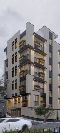 an apartment building with many balconies and plants on the top floor is lit up at night