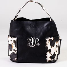 Who doesn't love cow print?! This baby is not only beautiful, but it's roomy too! Featuring two large exterior pockets, this bag has all the space you need for a day out. 11.5"h x 16"w, snap closure Black Bag With Cow Print For Everyday Use, Black Hobo Bag With Pockets For Errands, Trendy Cow Print Bags For Everyday Use, Rectangular Cow Print Travel Bag, Casual Everyday Bag With Cow Print, Brown Cow Print Bag For Everyday Use, Casual Cow Print Bags For Daily Use, Brown Cow Print Bag, Black Hobo Bag With Snap Closure For Travel