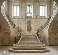 a large staircase in an old building with stone walls and arched doorways leading up to the second floor