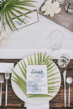 the table is set with white plates, silverware and place settings for an event