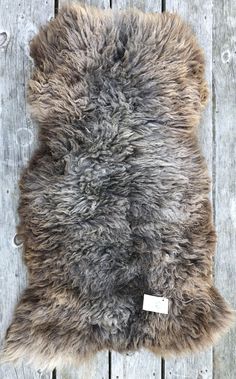 a sheepskin rug with a tag on it sitting on top of a wooden floor