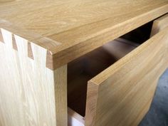 a close up of a wooden table with drawers on each side and an open drawer in the middle