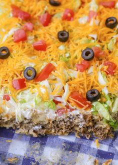 a casserole dish with cheese, lettuce and olives on top