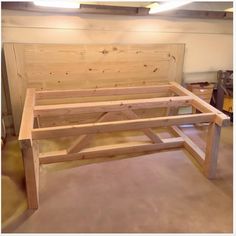 a wooden bed frame sitting on top of a hard wood floor next to a wall