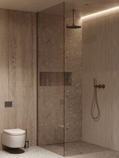 a bathroom with a toilet, shower and glass walls in the corner is lit by recessed lighting