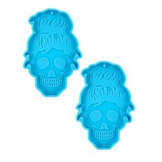 two blue skull shaped cookie cutters sitting next to each other on a white background