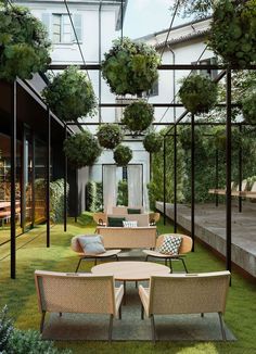 an outdoor seating area with chairs, tables and potted plants