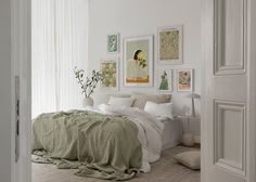 a bedroom with white walls and pictures on the wall