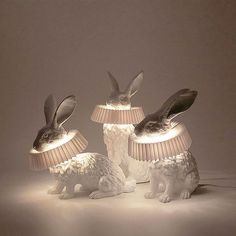 three rabbits sitting on top of lamps in the shape of lamps