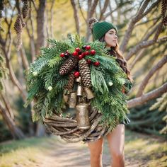 a woman carrying a christmas wreath and bells