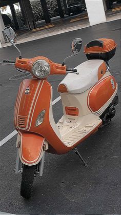 an orange and white scooter parked in a parking lot