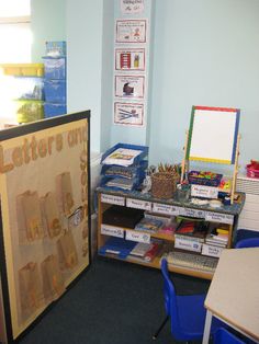 a classroom with blue chairs and a bulletin board